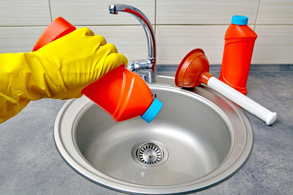 a person pouring chemical drain cleaner down the sink Kirkland, WA