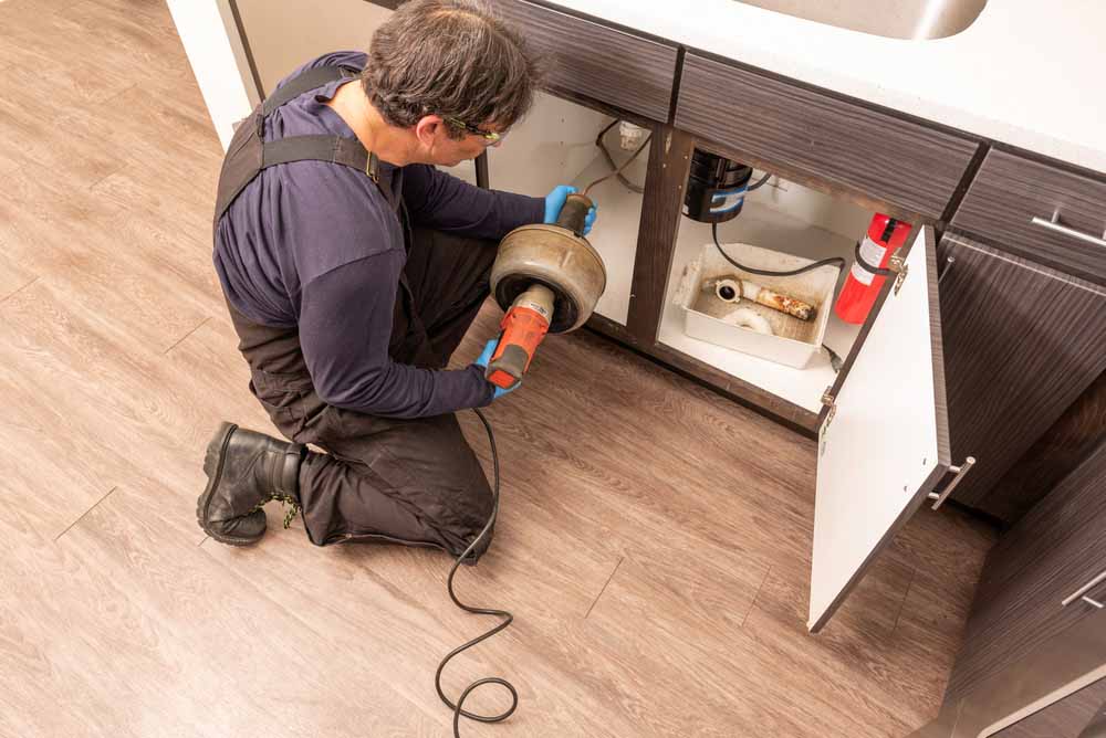 technician snaking a drain